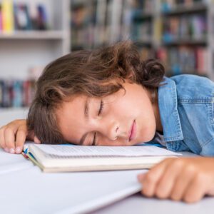 boy sleeping his notebook after doing his homework Apna Edukation Wala