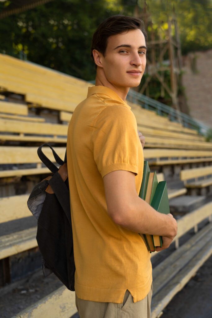 side view smiley man carrying books Apna Edukation Wala