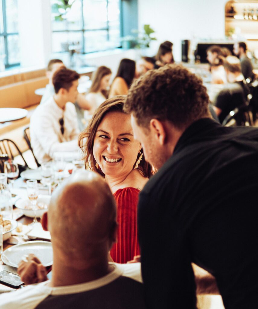 Man Standing Behind Sitting Couple